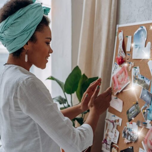 A woman creating a vision board in order to manifest her dreams