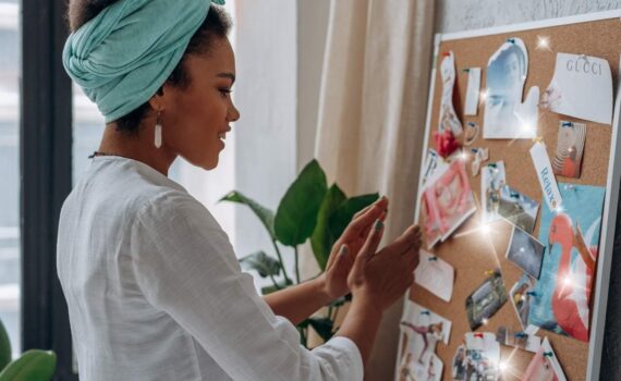 A woman creating a vision board in order to manifest her dreams