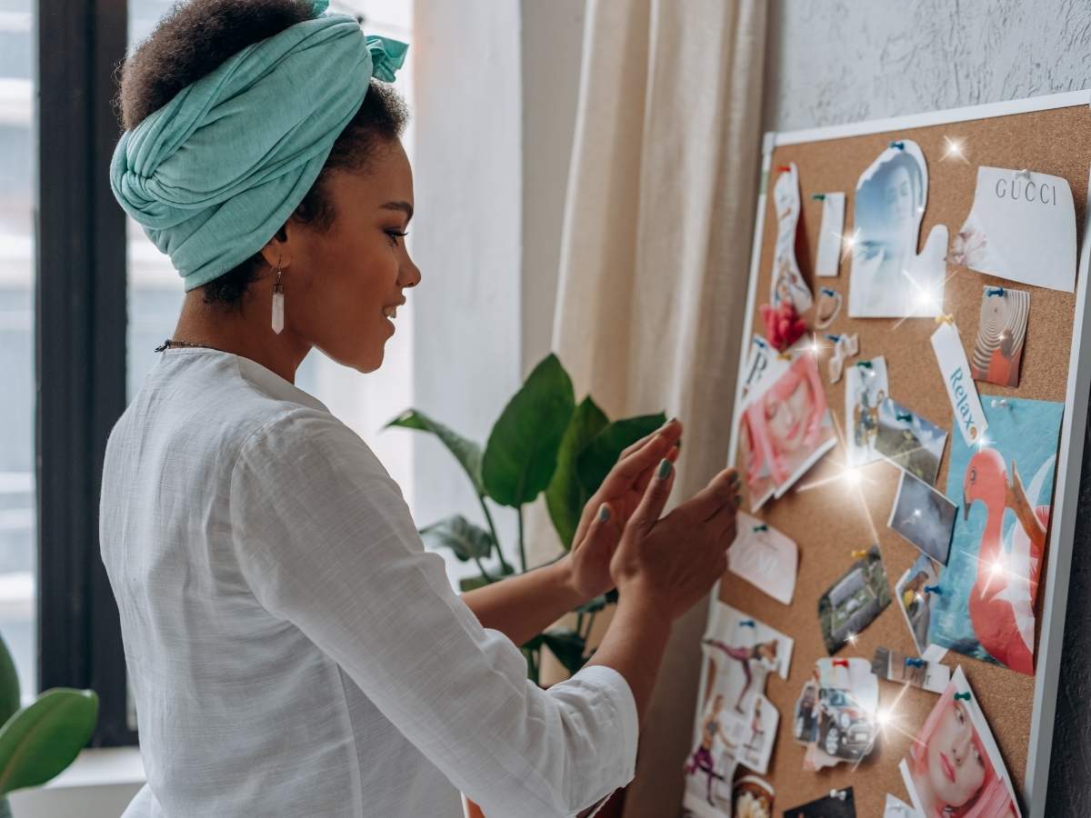 A woman creating a vision board in order to manifest her dreams