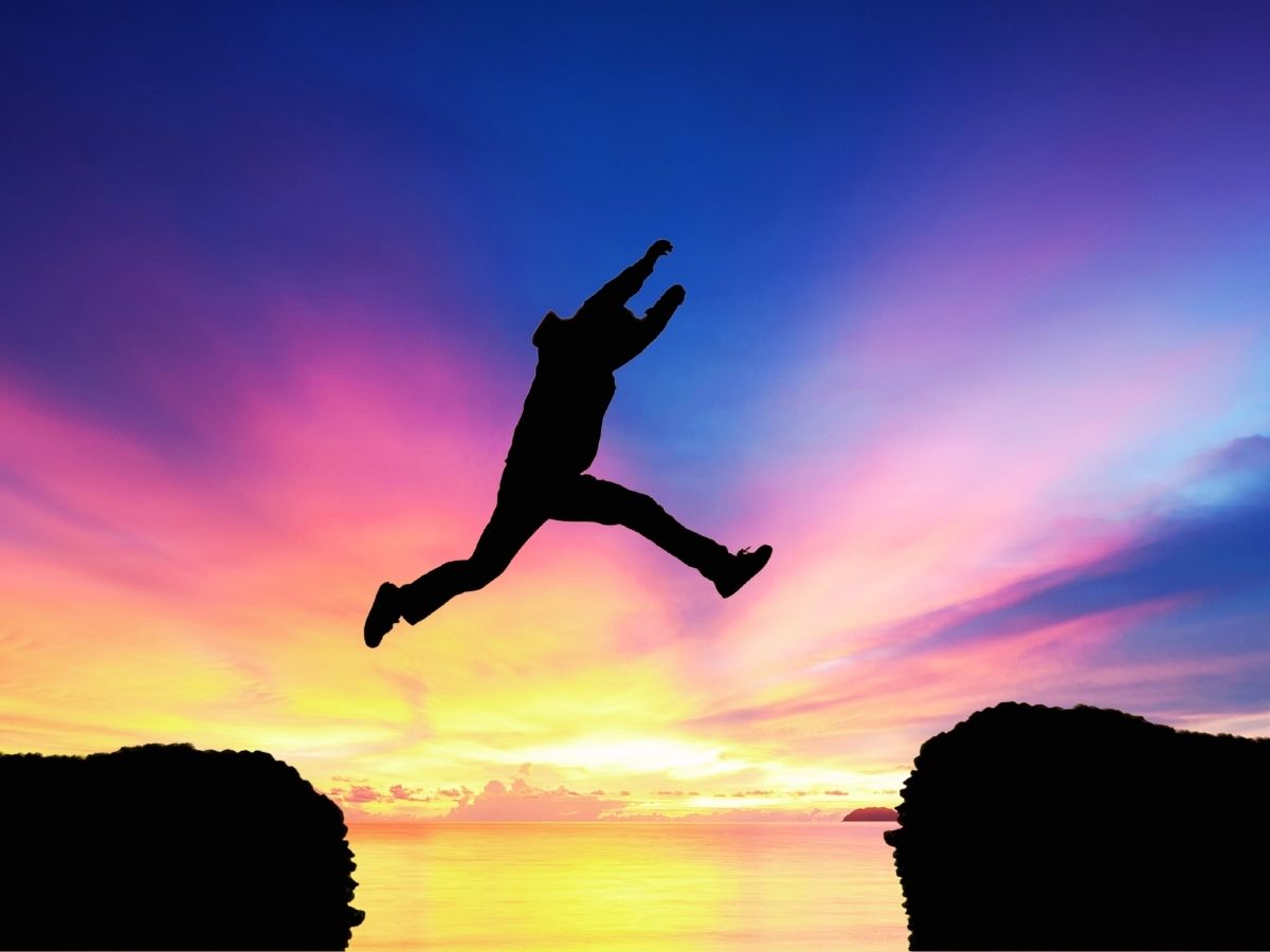 Illustration of a person taking a big leap of faith from one side of a cliff to another